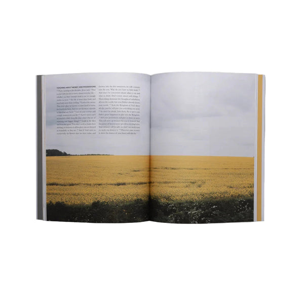 Open book showing a photograph of a field on one page and text on the other, on a white background.