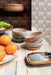 4 retro style dessert bowls with reactive glaze finish on a table with tangerines