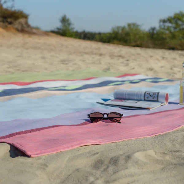 striped blanket on beach with sunglasses