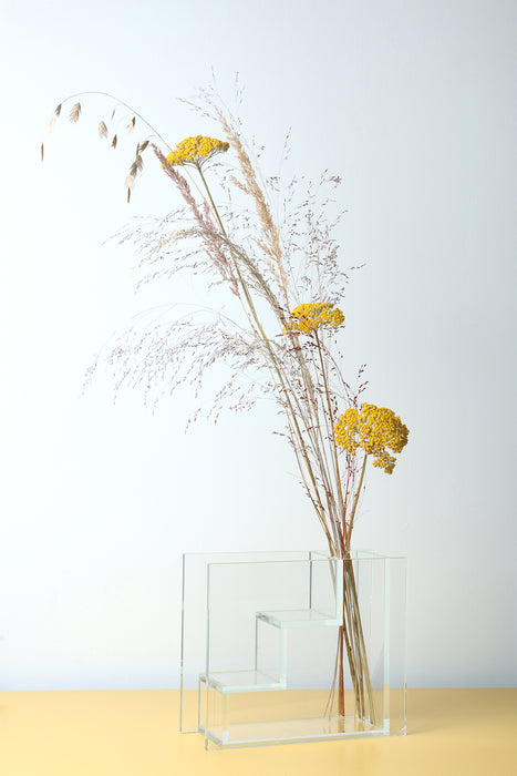 glass staircase vase with yellow flowers