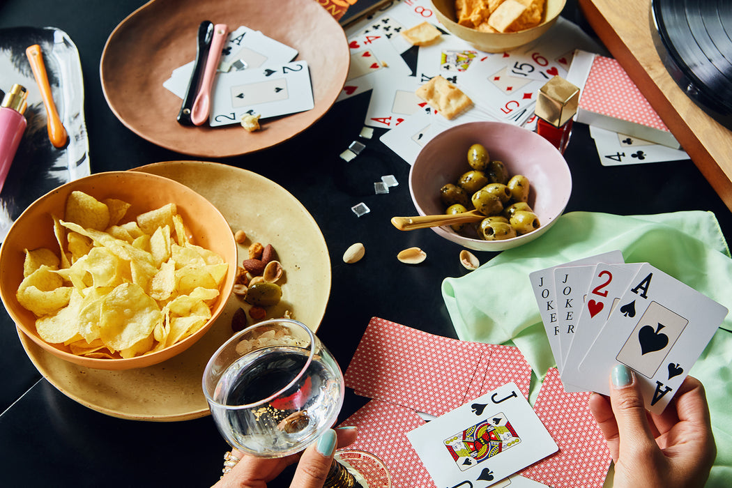 party table with cards, olives, potato chips and porcelain plates