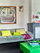 velvet mint green sofa with yellow pillows and a green coffee table with photobooks