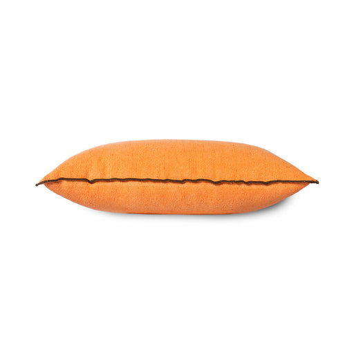 side view of orange linen lumbar pillow with brown cotton trim