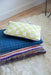 checkered cotton pillow in bright colors on a blue throw blanket