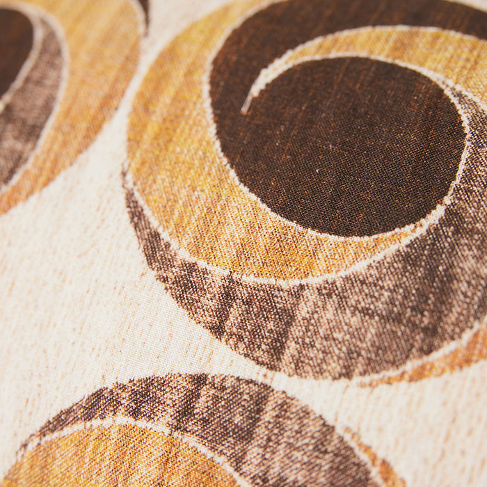 fabric close up of lumbar pillow with brown vintage circles