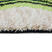 detail of long runner made from hand knotted natural wool with neon green and black pattern