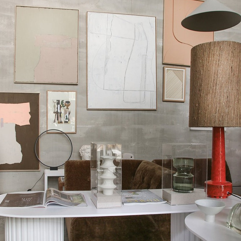 grey wall with framed, abstract paintings and art works