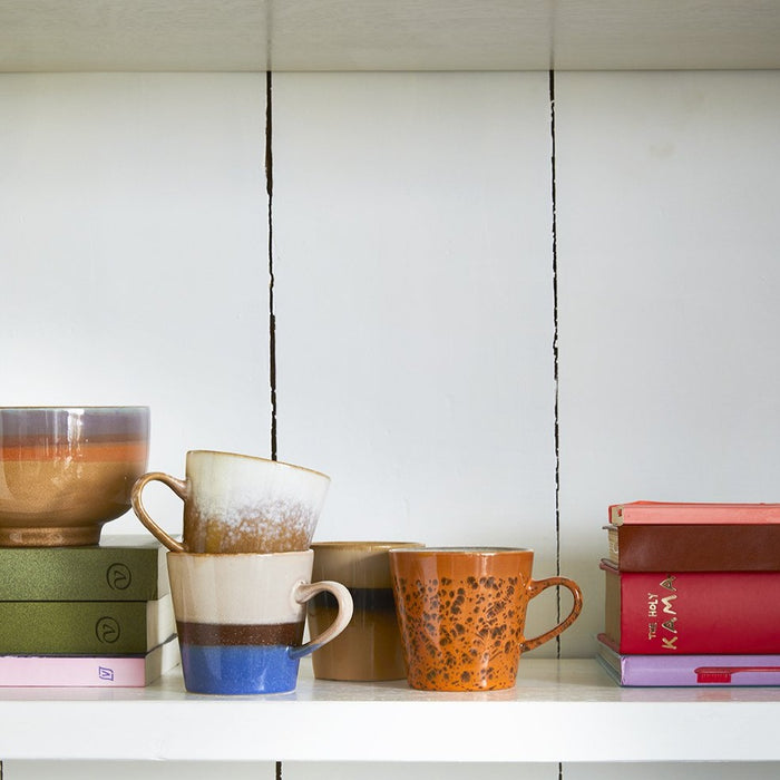 wooden cabinet with open shelving and a set of 4 bold colored americano mugs with a 70's style texture