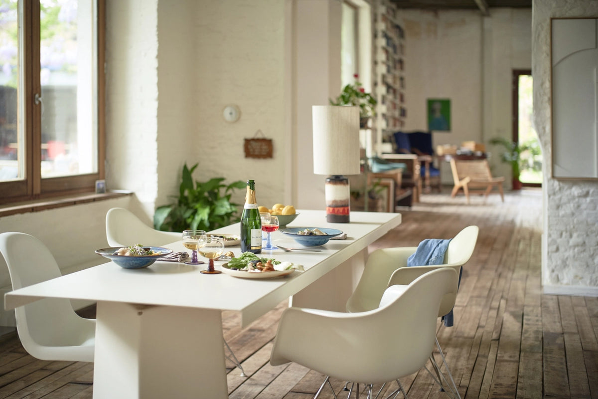 white dining table with blue pasta plates and a bottle of prosecco