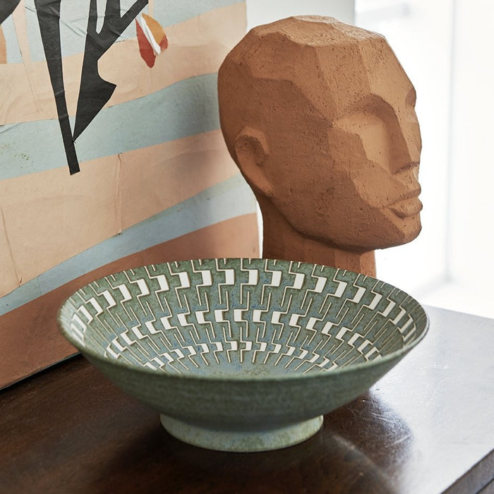 green bowl and terracotta head sculpture