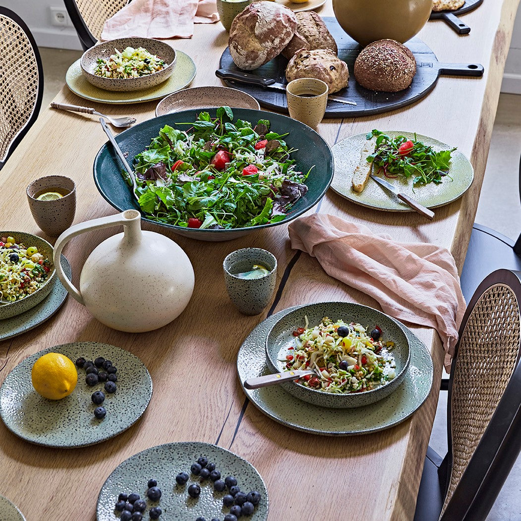 table with salad served in deep plates