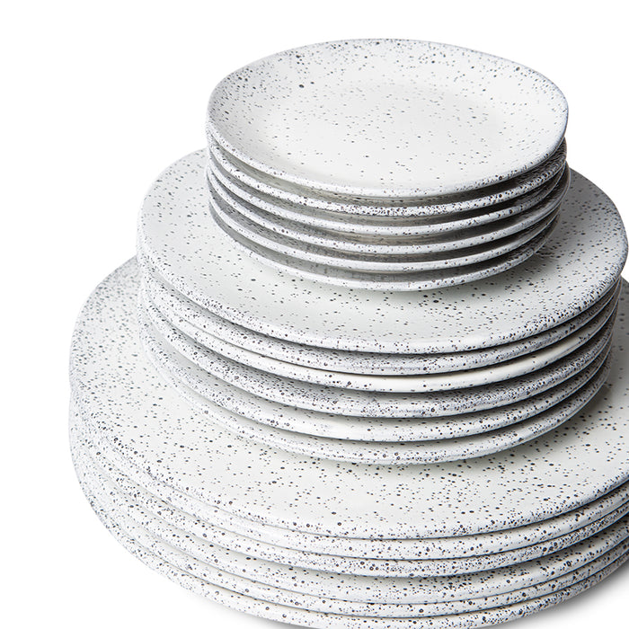 set of off white dinner, side and appetizer plates in a white color with charcoal speckles and reactive glaze finish