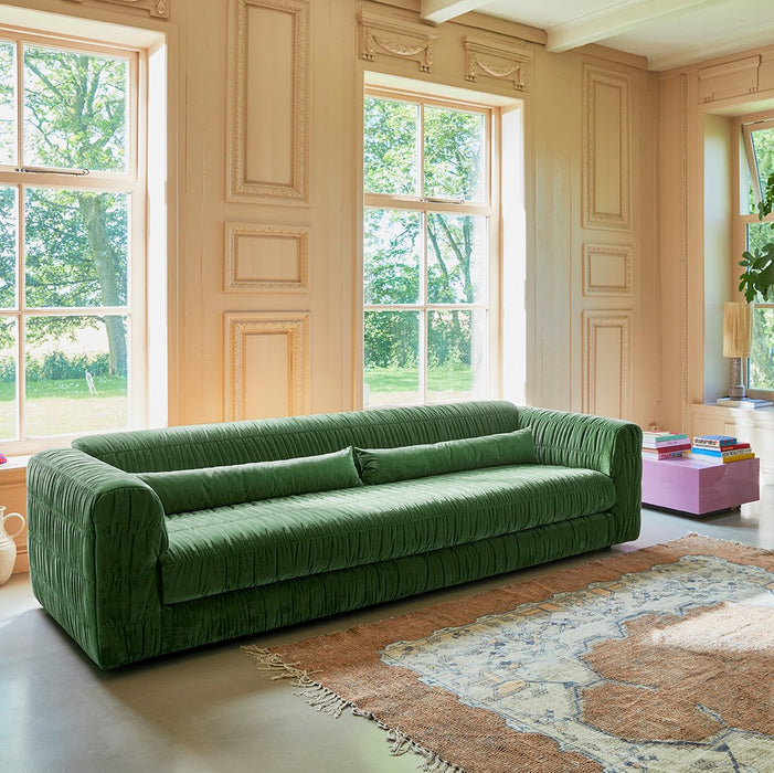green large sofa in living room with large windows