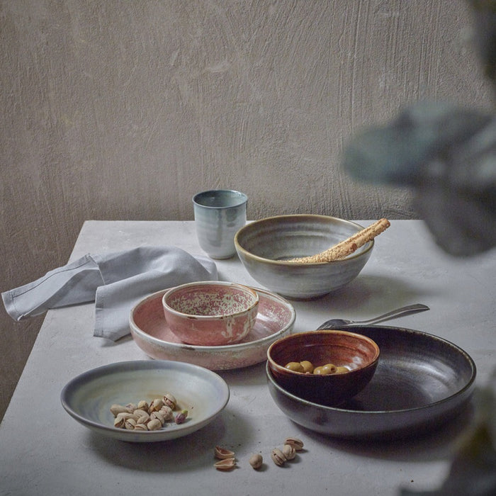 deep plates made from hotel porcelain in grey pink and black on a table