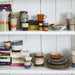 open shelving with books, plates, cups and the HKliving storage jar called Tropical
