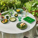 outdoor table setting with green table ware on a natural linen table cloth