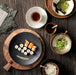 table with dinnerware and edema beans and sushi on black plate