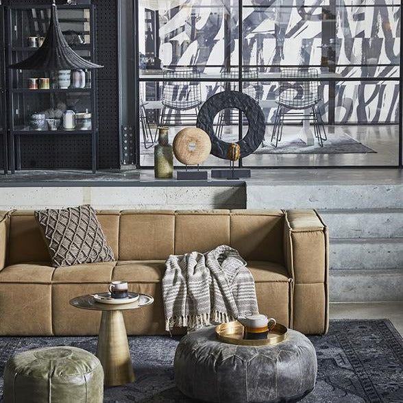 khaki brown couch and leather poufs with brown throw blanket in living room