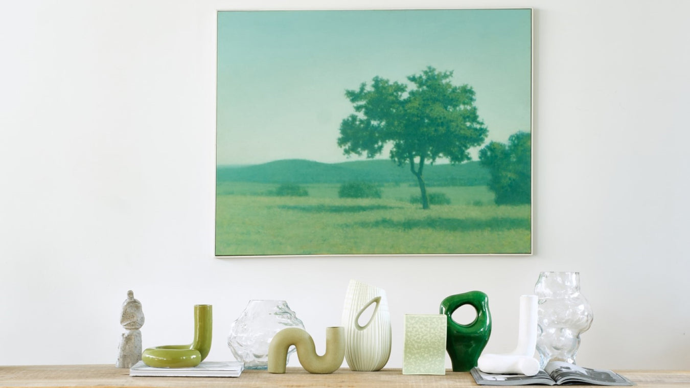 green painting and green and glass vases on wooden table