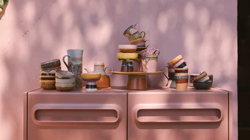 stoneware cups, bowls and spoons on open shelving in retro style kitchen