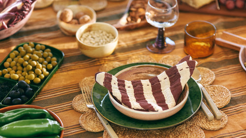 cotton napkins with a retro vibe next to a stack of dinner plates