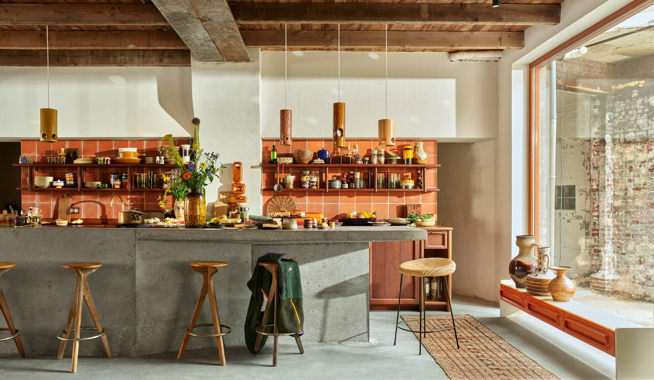 retro style kitchen with wooden stools, ceramic pendant light and terracotta tiles