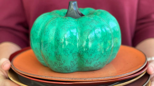 green pumpkin on orange plate