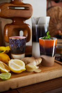 two retro style tall tea mugs with texture and earthy colors with ginger and lemon and mint