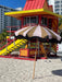 mustard and nude striped parasol with wooden pole on beach in miami