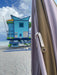 miami beach with detail of mustard and nude striped parasol with wooden pole