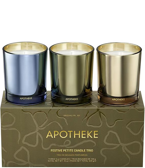 Three Apotheke candles in blue, gold, and bronze on a branded box.