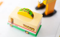 Toy taco truck with a taco on top, resembling a fast food vehicle.