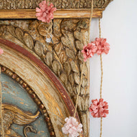 Decorative mirror with floral accents on a white wall