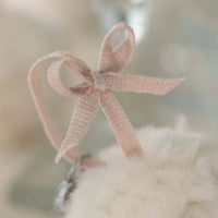 Close-up of a pink ribbon bow on a blurred background