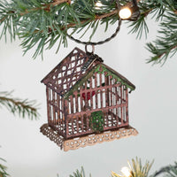 Decorative birdhouse ornament hanging on a Christmas tree branch.