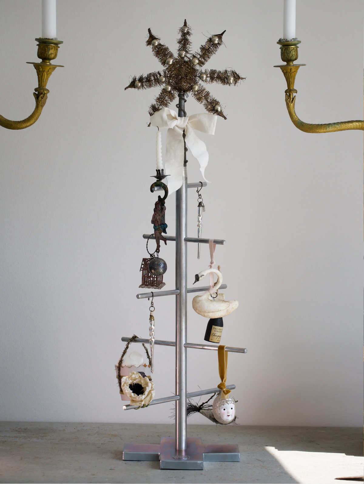 metal Christmas tree with antique inspired ornaments on white background