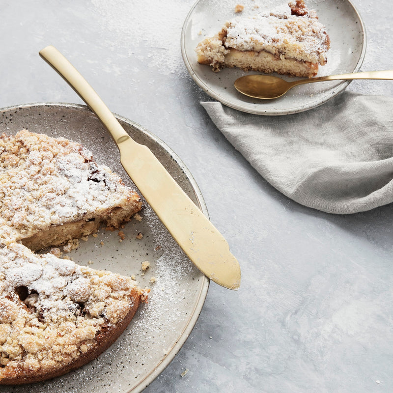 gold colored cake serving knife with apple pie