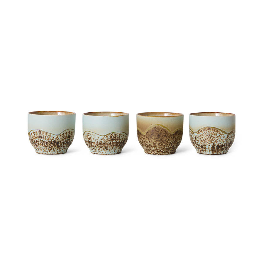 Set of four ceramic cups with a textured design on a white background