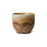 Ceramic cup with a textured brown design on a white background
