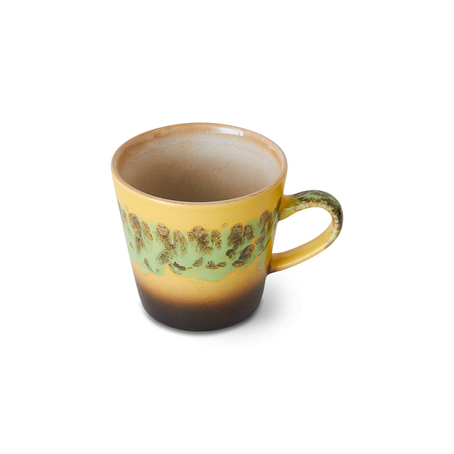 Yellow mug with green pattern on a white background