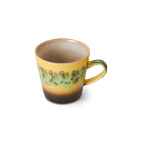 Yellow mug with green pattern on a white background