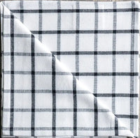 Plaid fabric with black and white pattern on a wooden surface