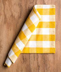 Yellow and white checkered towel on a wooden surface