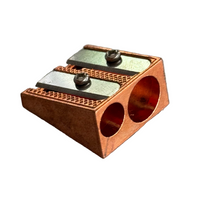Copper pencil sharpener on a gray marble surface