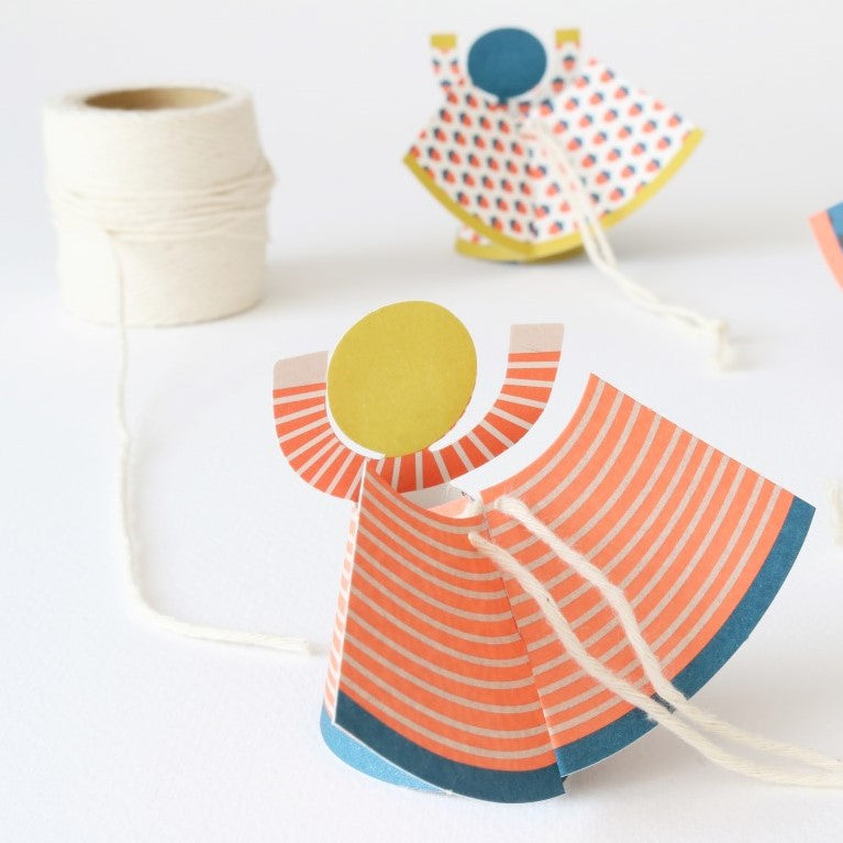 Colorful paper dress with a yellow circle on a white background