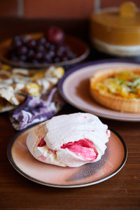 stoneware dessert plate peach pink color variations with a  piece of merengue cake