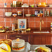 retro style footed bowl with lid in open shelving in kitchen with orange tiles