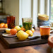 lemons, tangerines and glass and ceramic tall and low tumbler mugs in kitchen