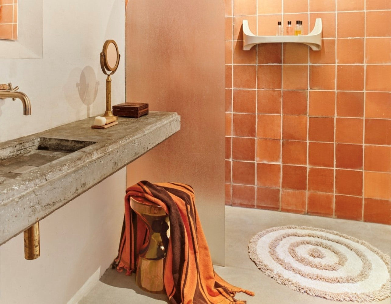 round bath mat with high and low pile and cream and beige color in bathroom with orange tiles