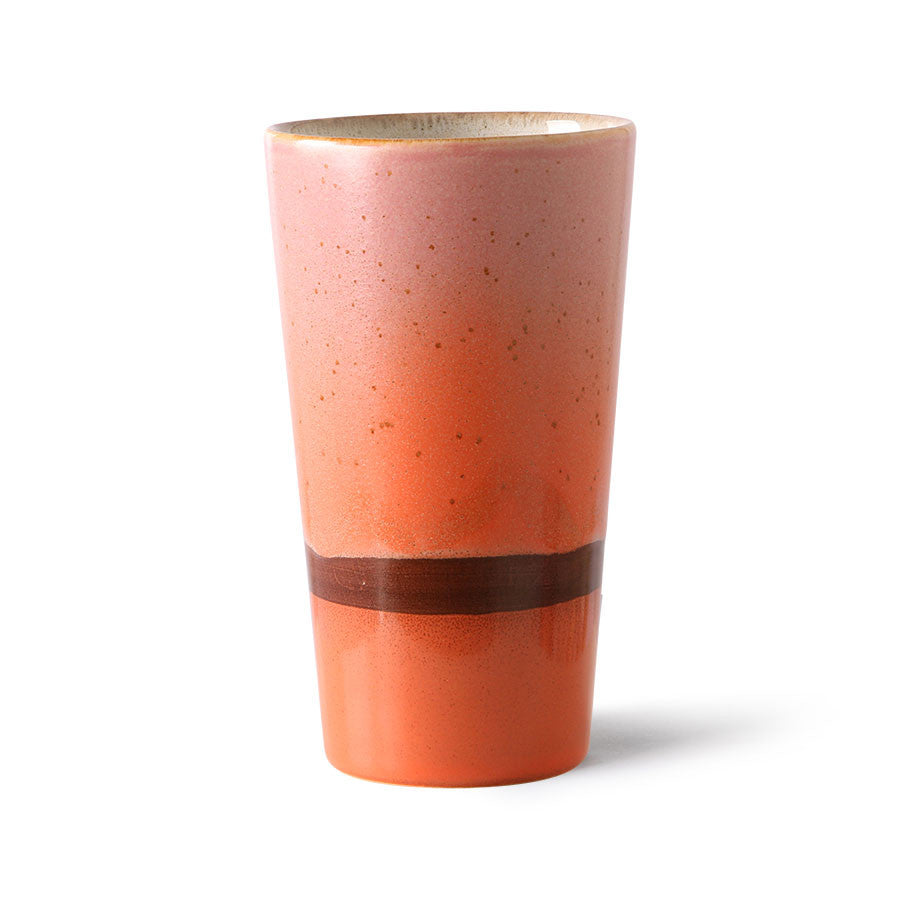 Ceramic tumbler with a gradient color from pink to orange on a white background